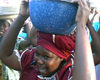 Chad - N'Djamena: woman with heavy cargo - photo by S.Montevecchi