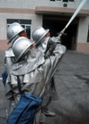 Dongguan, Guangdong province, China: Chinese firemen - with hose - photo by B.Henry