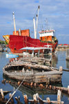 Moroni, Grande Comore / Ngazidja, Comoros islands: the freighter 'Moroni' and old dhow hulls - Port aux Boutres - photo by M.Torres