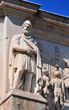 Rome, Italy: Arch of Constantine - statue of Dacian prisoner from the times of Trajan - cornice around the attic - photo by M.Torres