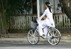 Hue - vietnam: students have to dress the tradional long tunic - girl on a bike - photo by Tran Thai