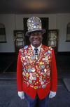 Victoria Falls - Mosi-oa-tunya, Matabeleland North province, Zimbabwe: Odwell Makamure, the famous doorman at the Victoria Falls Hotel proudly parades his collection of pins on his red coat and tall hat - photo by C.Lovell