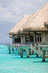 Papetoai, Moorea, French Polynesia: InterContinental Hotel - line of overwater bungalows backed by mountains on the north coast - tropical resort view - photo by D.Smith